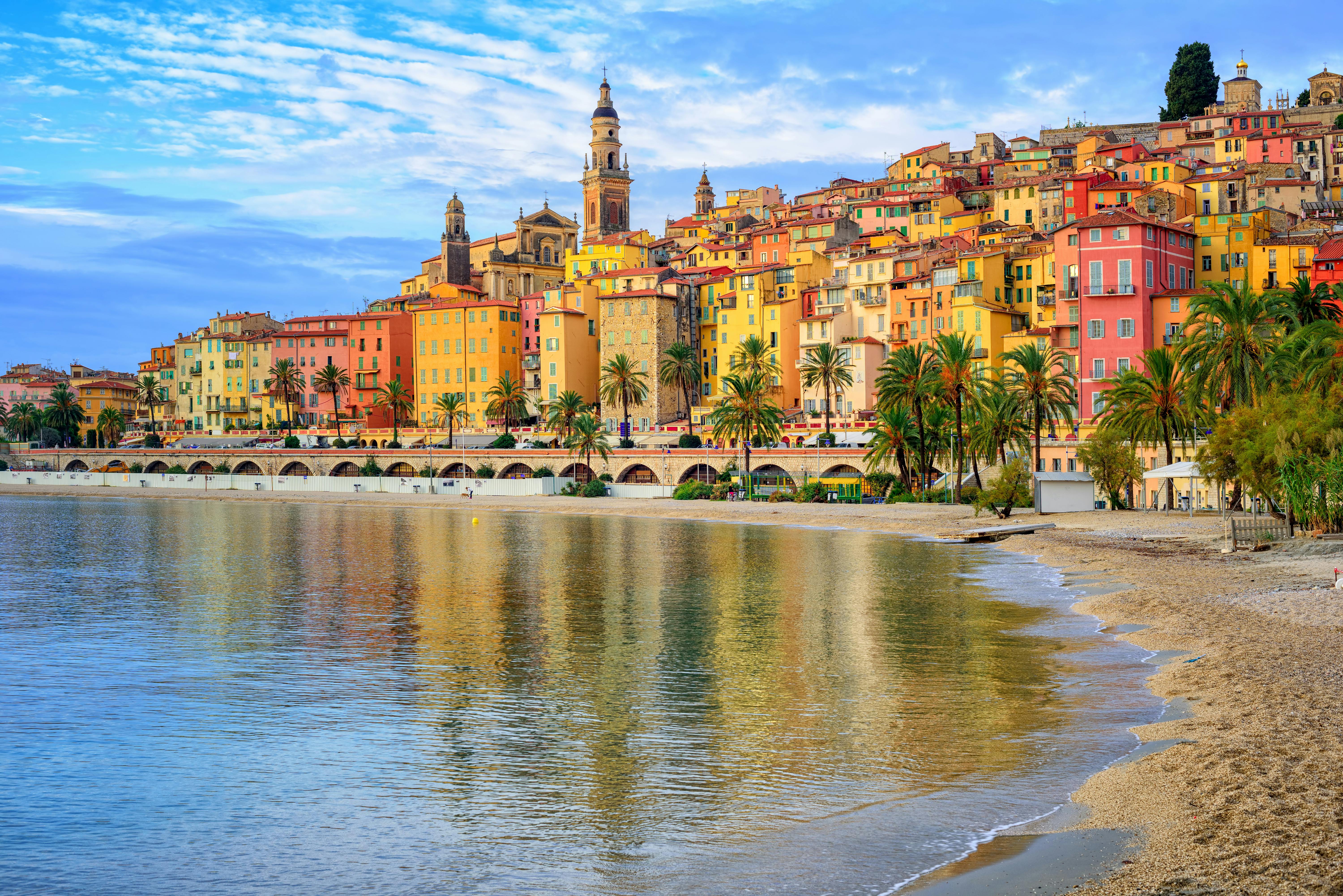 Sand beach beneath the colorful old town Menton in Nice on the French Riviera, France.